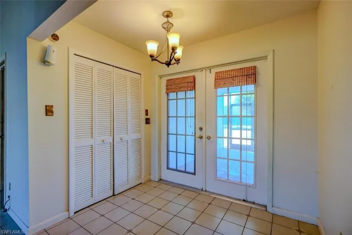 Doorway to outside featuring light tile patterned flooring and french doors