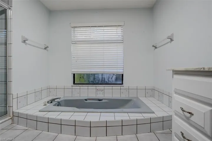 Bathroom featuring tile patterned flooring and independent shower and bath