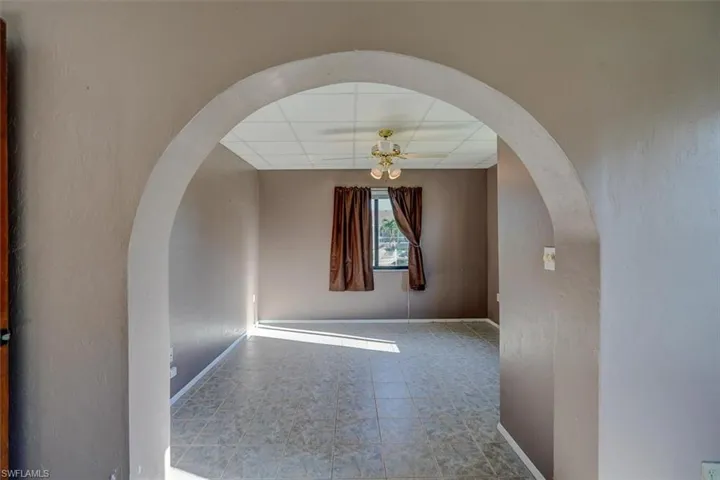 Nursery/sitting area in Primary bedroom featuring ceiling fan, a closet, a paneled ceiling, and light tile floors