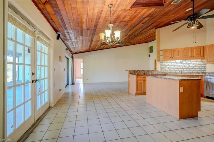 Kitchen featuring light brown cabinets, wood ceiling, and vaulted ceiling