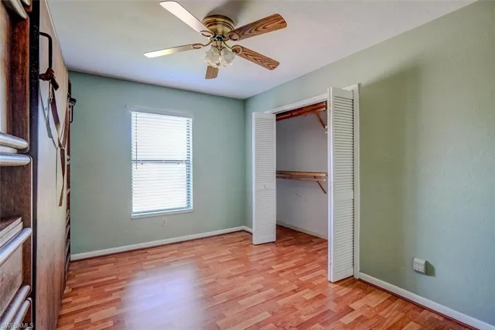 Unfurnished bedroom with light wood-type flooring, ceiling fan, and a closet