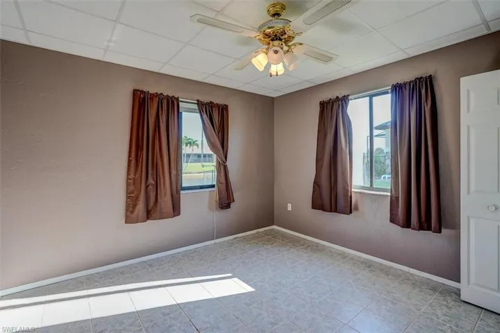 Nursery/sitting area in Primary bedroom featuring ceiling fan, a closet, a paneled ceiling, and light tile floors