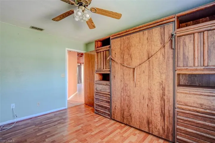 Murphy bed, bedroom with ceiling fan and hardwood / wood-style floors