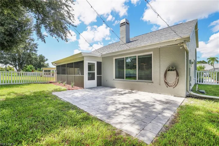Rear view of property featuring a patio, a yard, and a patio