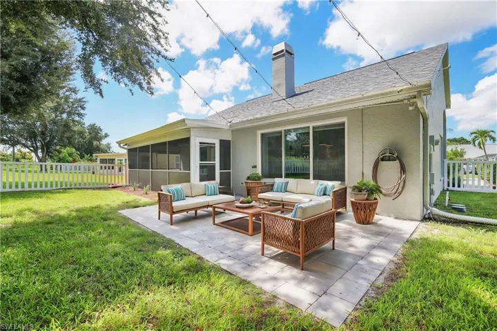 Back of house featuring a lawn, outdoor lounge area, a sunroom, and a patio