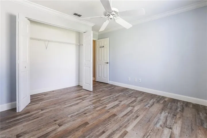 bedroom featuring crown molding, hardwood / wood-style floors, ceiling fan, and a closet