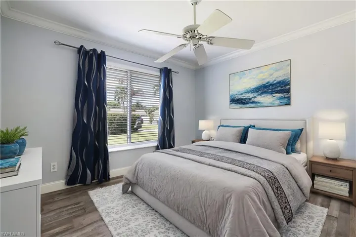 Bedroom featuring ceiling fan, ornamental molding, and dark hardwood / wood-style flooring