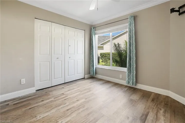 Unfurnished bedroom featuring a closet, ceiling fan, light hardwood / wood-style floors, and crown molding