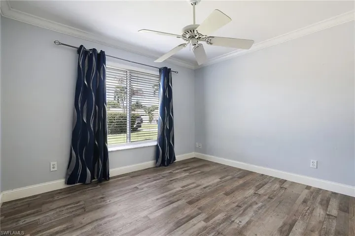 bedroom with ceiling fan, crown molding, and wood-type flooring