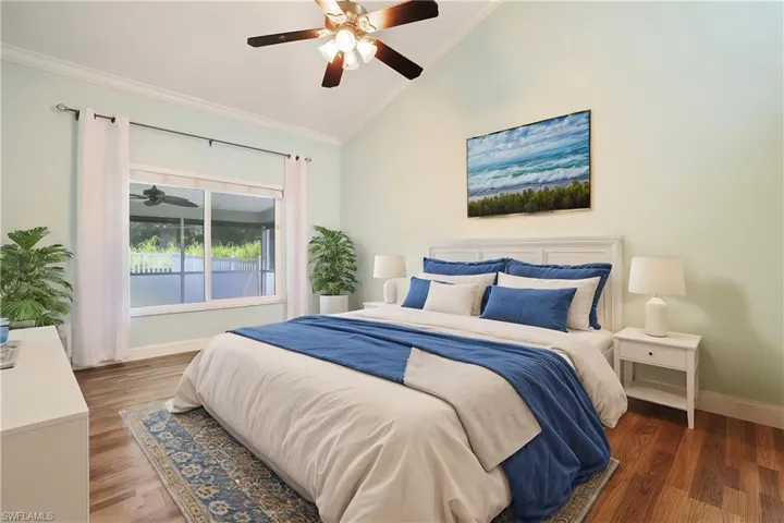Bedroom featuring ornamental molding, vaulted ceiling, ceiling fan, and wood-type flooring