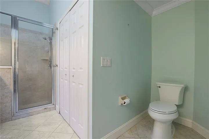 Bathroom featuring crown molding, toilet, and walk in shower