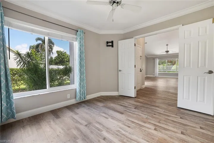 bedroom or den featuring crown molding, ceiling fan, and wood-type flooring