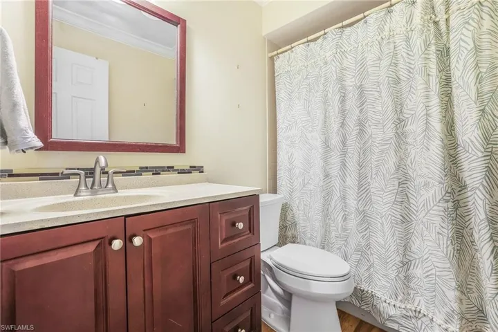 Bathroom with crown molding, vanity, toilet, and hardwood / wood-style flooring