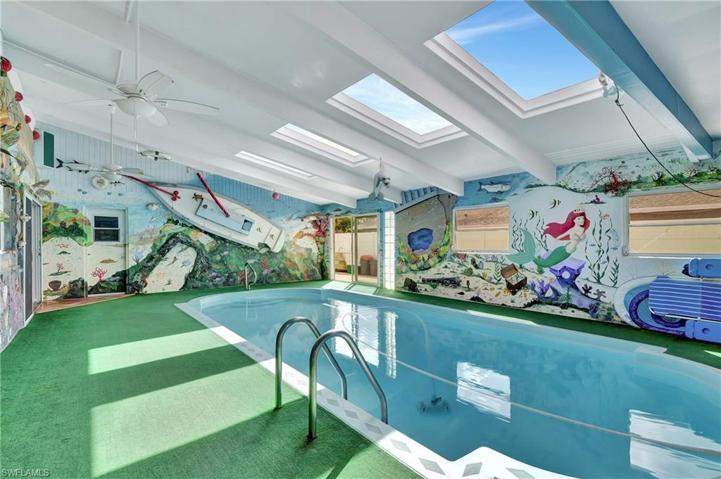 Indoor pool with skylights and art on all four walls