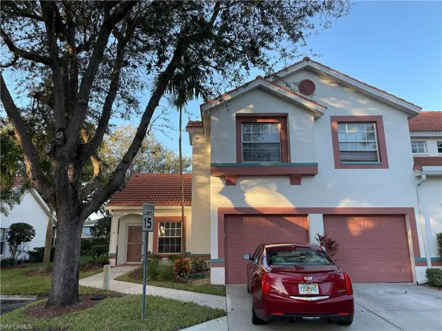Mediterranean / spanish house with stucco siding, driveway, a tiled roof, and a garage