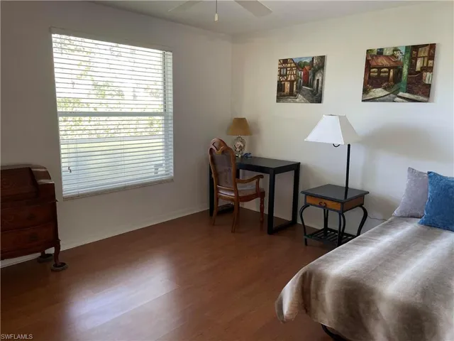 Bedroom with dark wood-style flooring and a ceiling fan