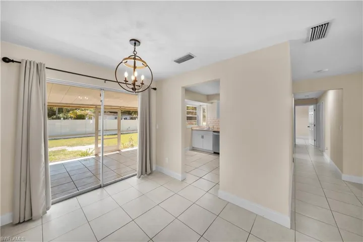 Unfurnished dining area featuring visible vents, a chandelier, and light tile patterned floors