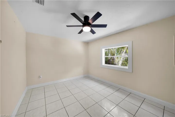 Empty room featuring baseboards, visible vents, and a ceiling fan