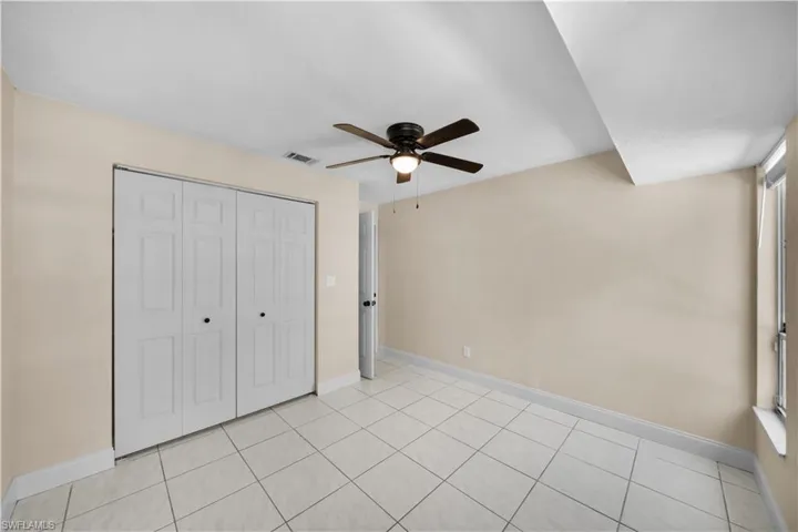 Unfurnished bedroom featuring light tile patterned flooring, baseboards, a closet, and visible vents