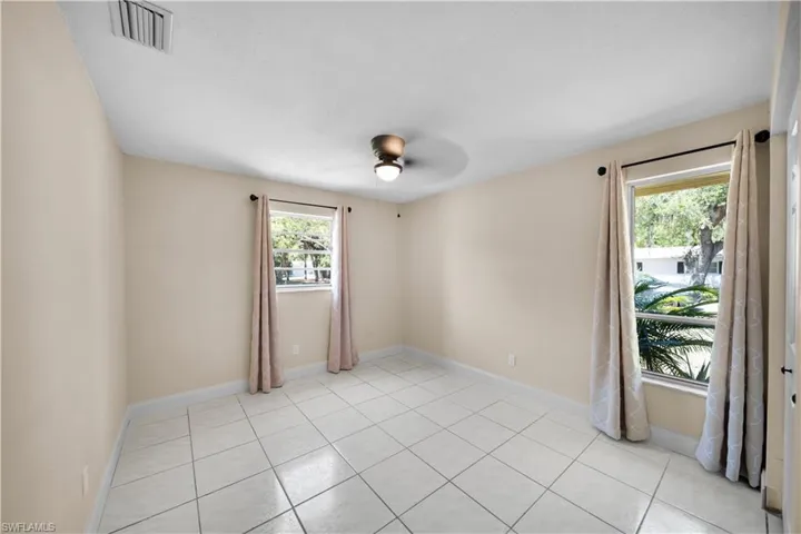 Unfurnished room with baseboards, ceiling fan, visible vents, and light tile patterned floors