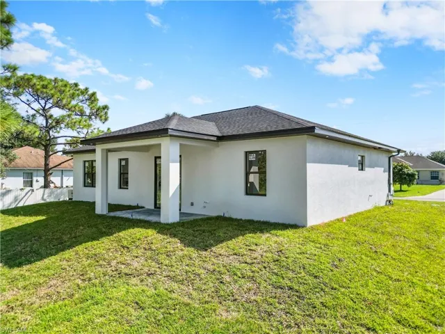 Rear view of house featuring a lawn