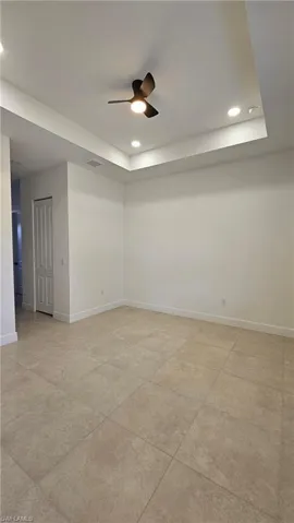 Spare room with recessed lighting, a tray ceiling, and ceiling fan