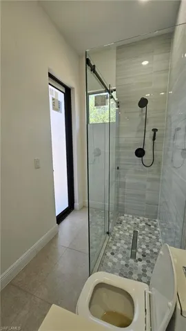 Bathroom featuring a shower stall and tile patterned flooring