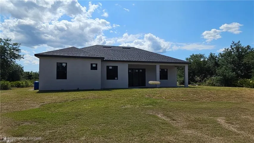 Back of property featuring a yard, stucco siding, and a shingled roof