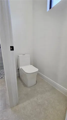 Bathroom with toilet and baseboards