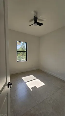 Spare room with baseboards and a ceiling fan