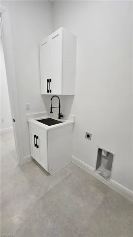 Washroom with electric dryer hookup and cabinet space