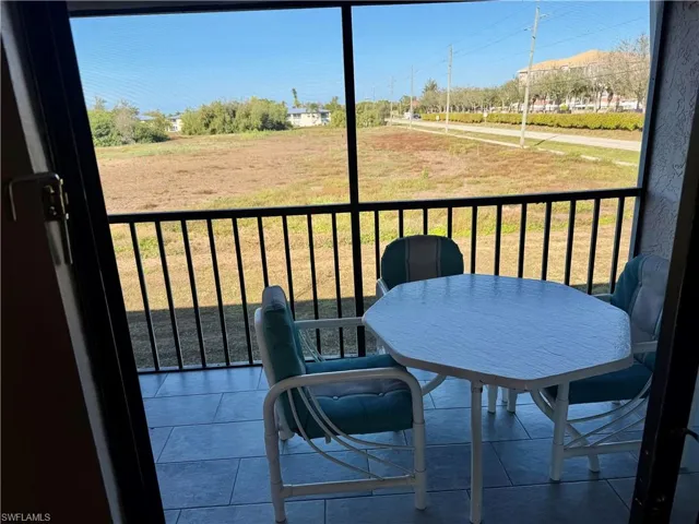 Balcony featuring outdoor dining space and a sunroom