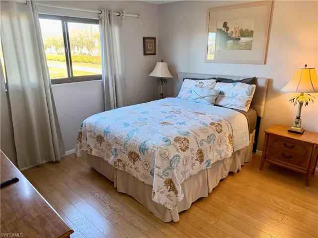 Bedroom featuring wood-type flooring and baseboards