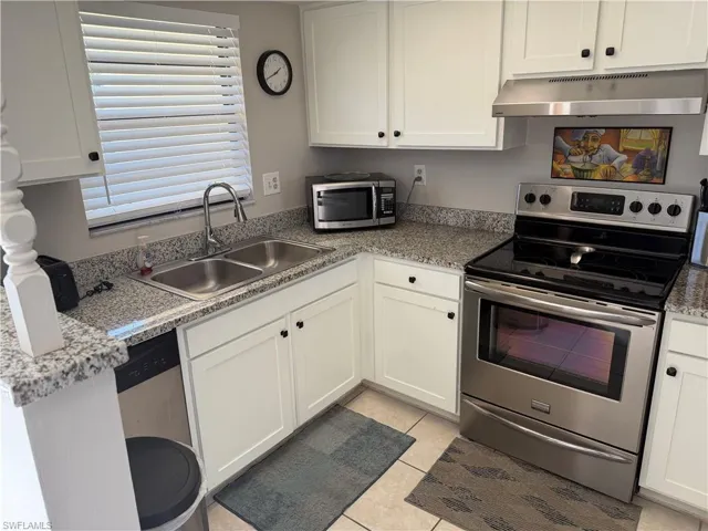 Kitchen featuring stainless steel appliances and white cabinets