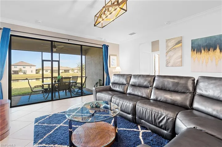 Tiled living area featuring crown molding, a ceiling fan, a sunroom, and a residential view