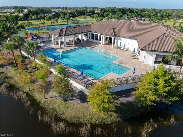 Community pool/ lap pool with a patio, view of wooded area, and a water view