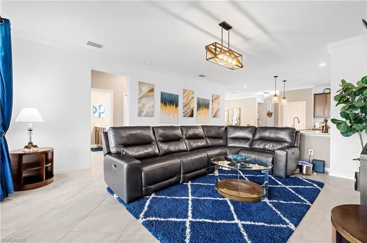 Living area featuring crown molding, light tile patterned floors, and recessed lighting