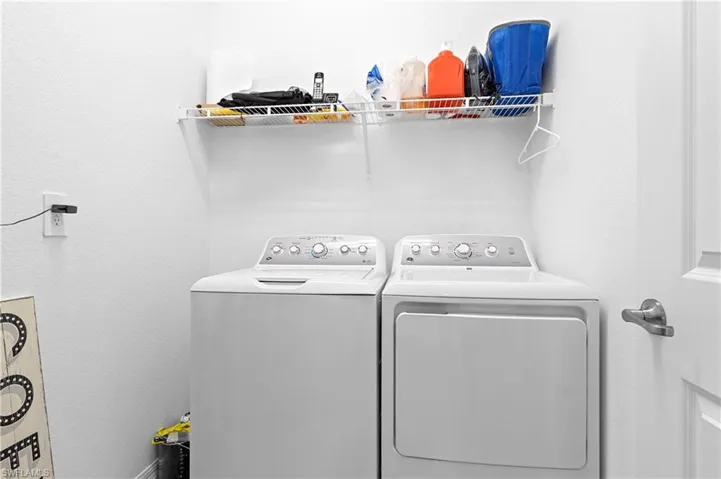 Laundry area with separate washer and dryer and a textured wall