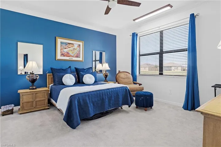 Bedroom featuring ornamental molding, a ceiling fan, and light colored carpet