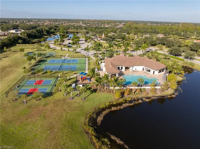 Drone / aerial view of a nearby body of water and a pool area