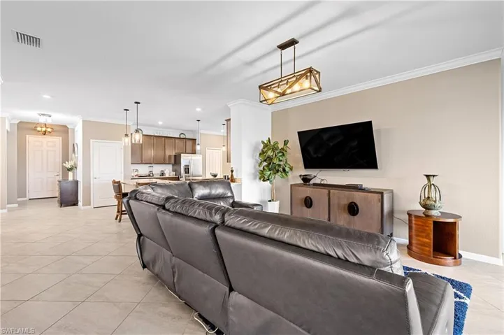 Living room featuring crown molding, light tile patterned floors, and recessed lighting