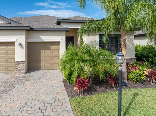 View of front of home featuring decorative driveway, stucco siding, an attached garage, and roof with shingles