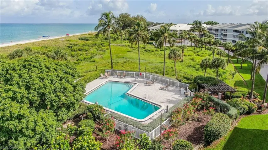 View of pool with a water view, a beach view, and a patio area