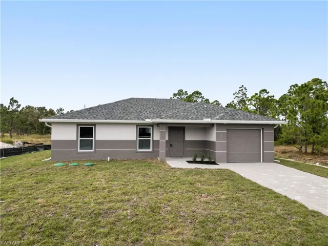 Single story home with stucco siding, a front yard, and driveway