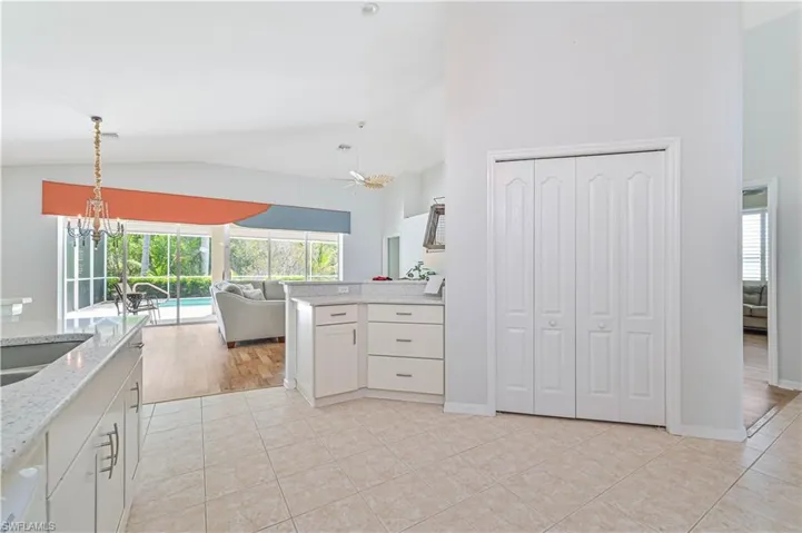 Kitchen featuring kitchen peninsula, light tile patterned floors, a notable chandelier, and hanging light fixtures