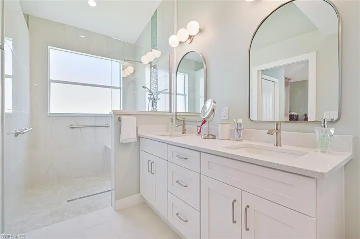 Bathroom with tile floors, dual sinks, a tile shower, and large vanity
