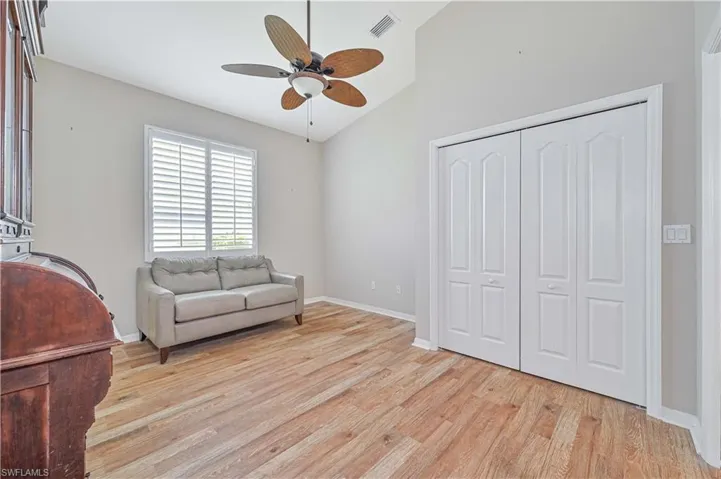 Living area featuring lofted ceiling, ceiling fan, and light hardwood / wood-style floors