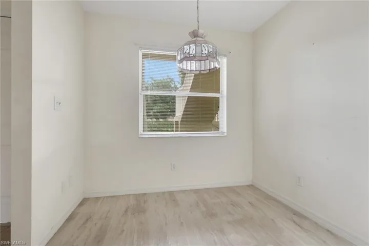 Unfurnished dining area featuring light wood-style flooring and baseboards