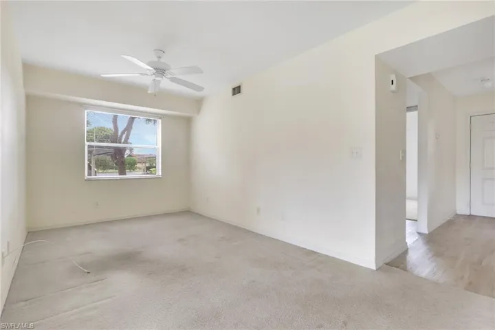 Unfurnished room featuring light carpet and a ceiling fan