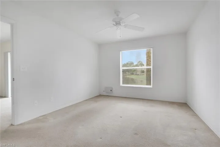 Empty room featuring light colored carpet and ceiling fan